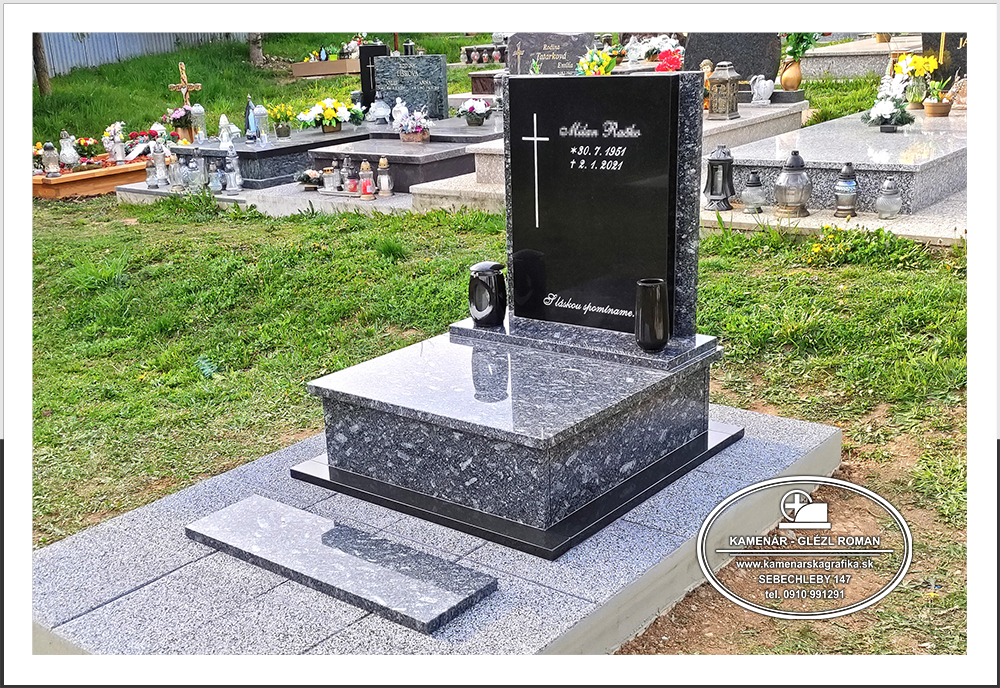 Urnový hrob s čiernou nápisnou tabuľou, svietnikom a vázou zo žuly a s betónovou dlažbou na cintoríne